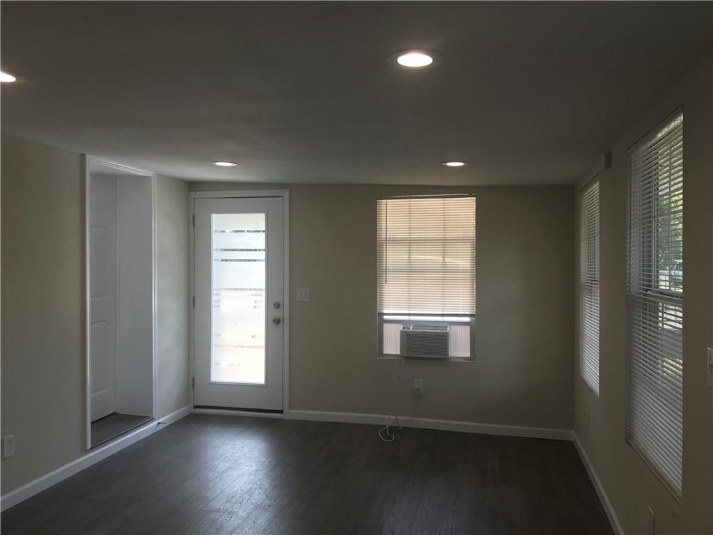 1119 Spur Street, Unit A Austin, TX 78721 - Photo 3 of 10 Recessed lighting illuminates wood flooring, leading to a frosted glass door and multiple sun-filtering windows.