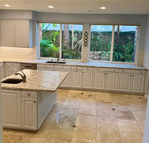 a kitchen with a sink window and cabinets