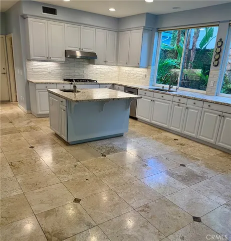 a kitchen with stainless steel appliances granite countertop a stove a sink and a refrigerator