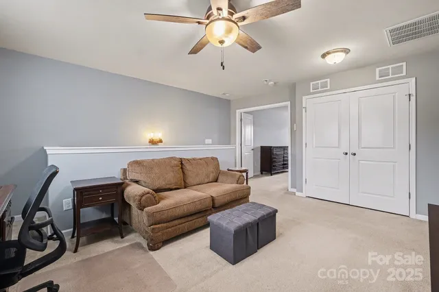 a living room with furniture and a ceiling fan