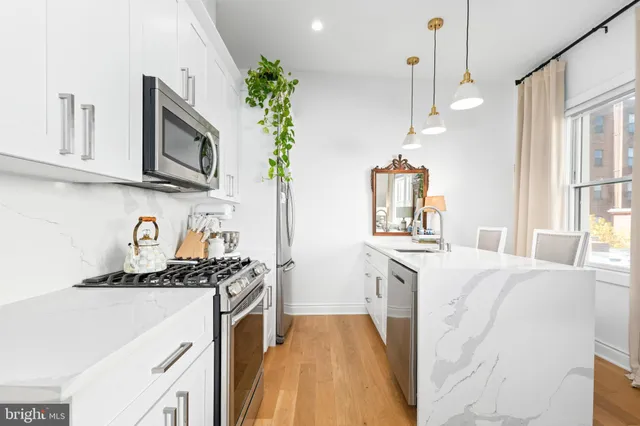 a kitchen with stainless steel appliances a stove a microwave sink and cabinets