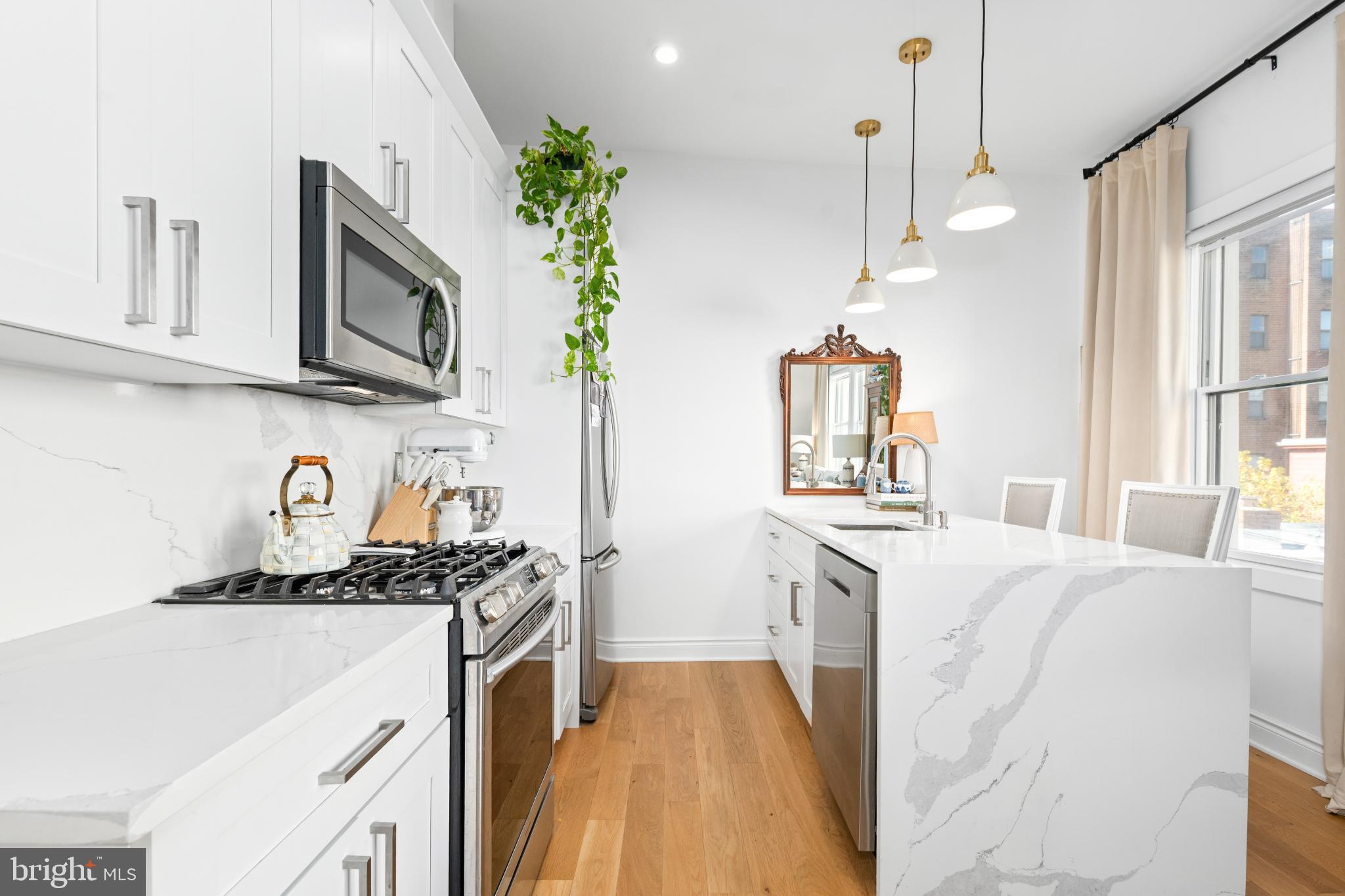 317 3rd Street Southeast, Unit 33 Washington, DC 20003 - Photo 14 of 26 a kitchen with granite countertop a sink stove and cabinets