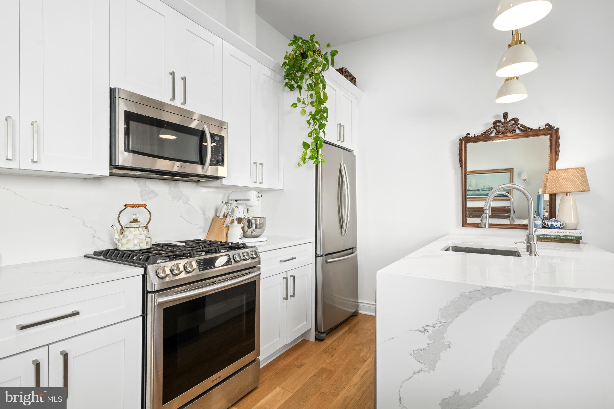 317 3rd Street Southeast, Unit 33 Washington, DC 20003 - Photo 15 of 26 a kitchen with stainless steel appliances a stove a microwave sink and cabinets