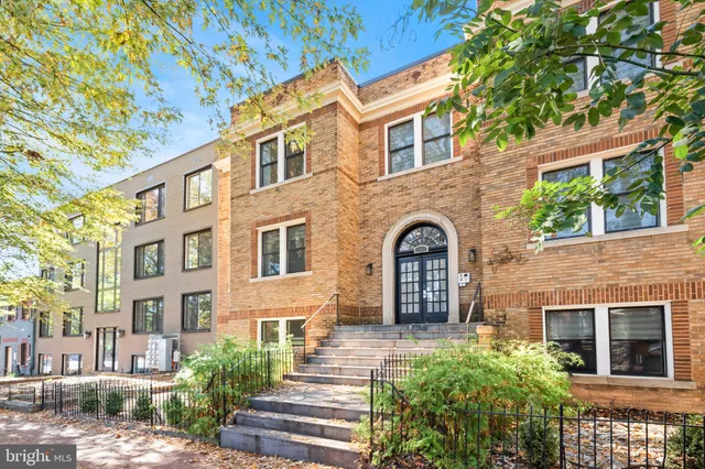 a front view of a building with a garden