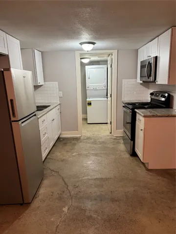 a kitchen with granite countertop a refrigerator stove and sink