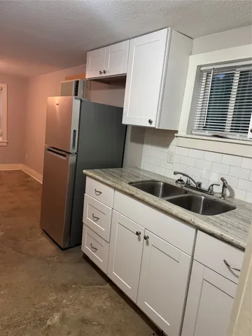 a kitchen with stainless steel appliances a refrigerator sink and cabinets