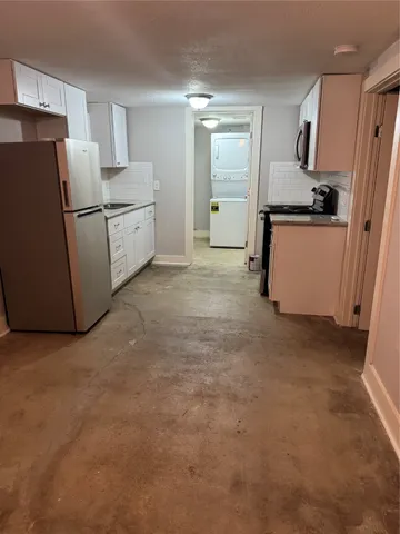a kitchen with refrigerator and white cabinets
