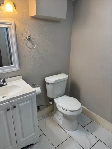 a white toilet sitting next to a bathroom sink