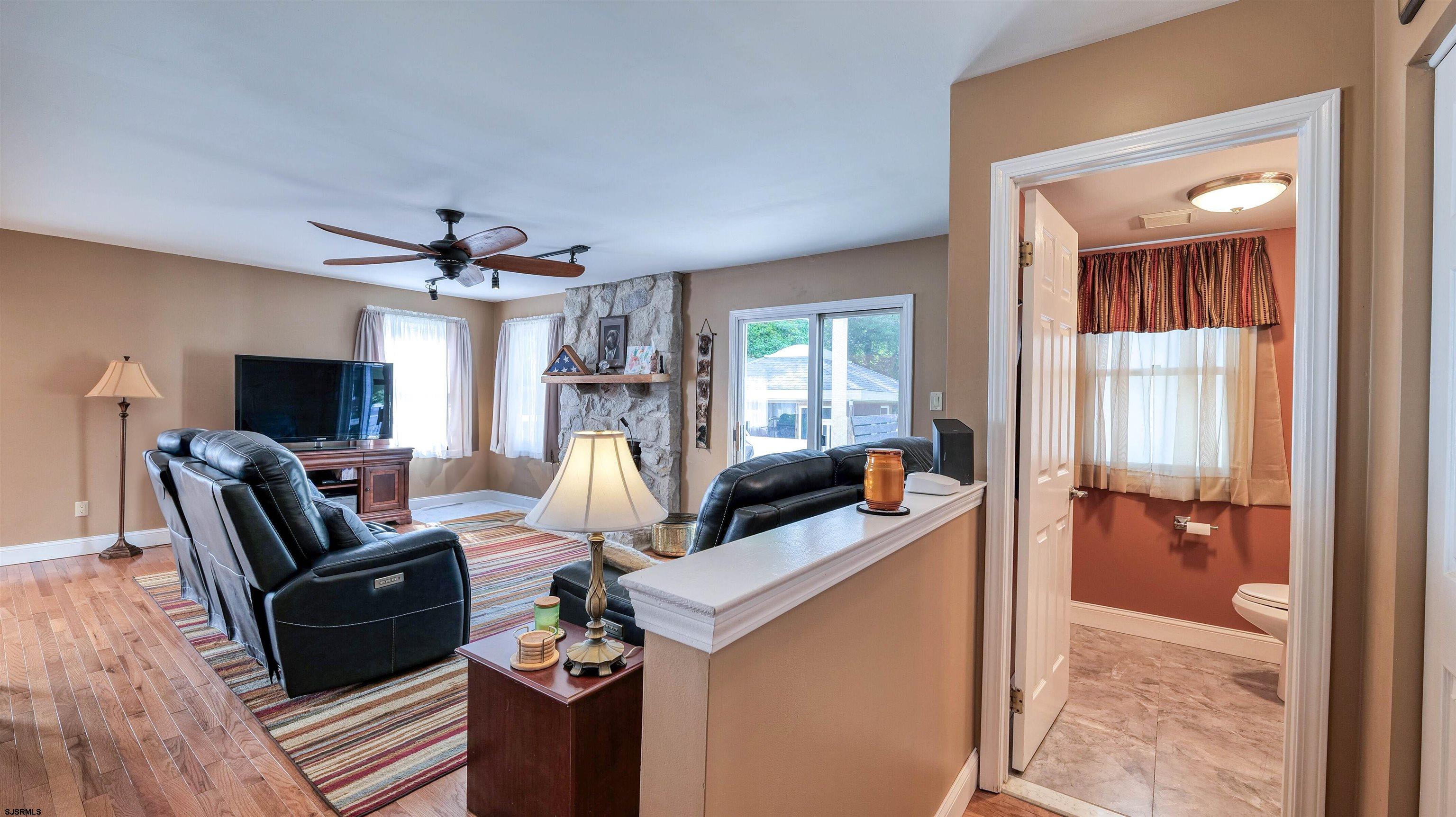 209 Reed Road Absecon, NJ 08201 - Photo 11 of 57 a living room with furniture a flat screen tv and a fireplace