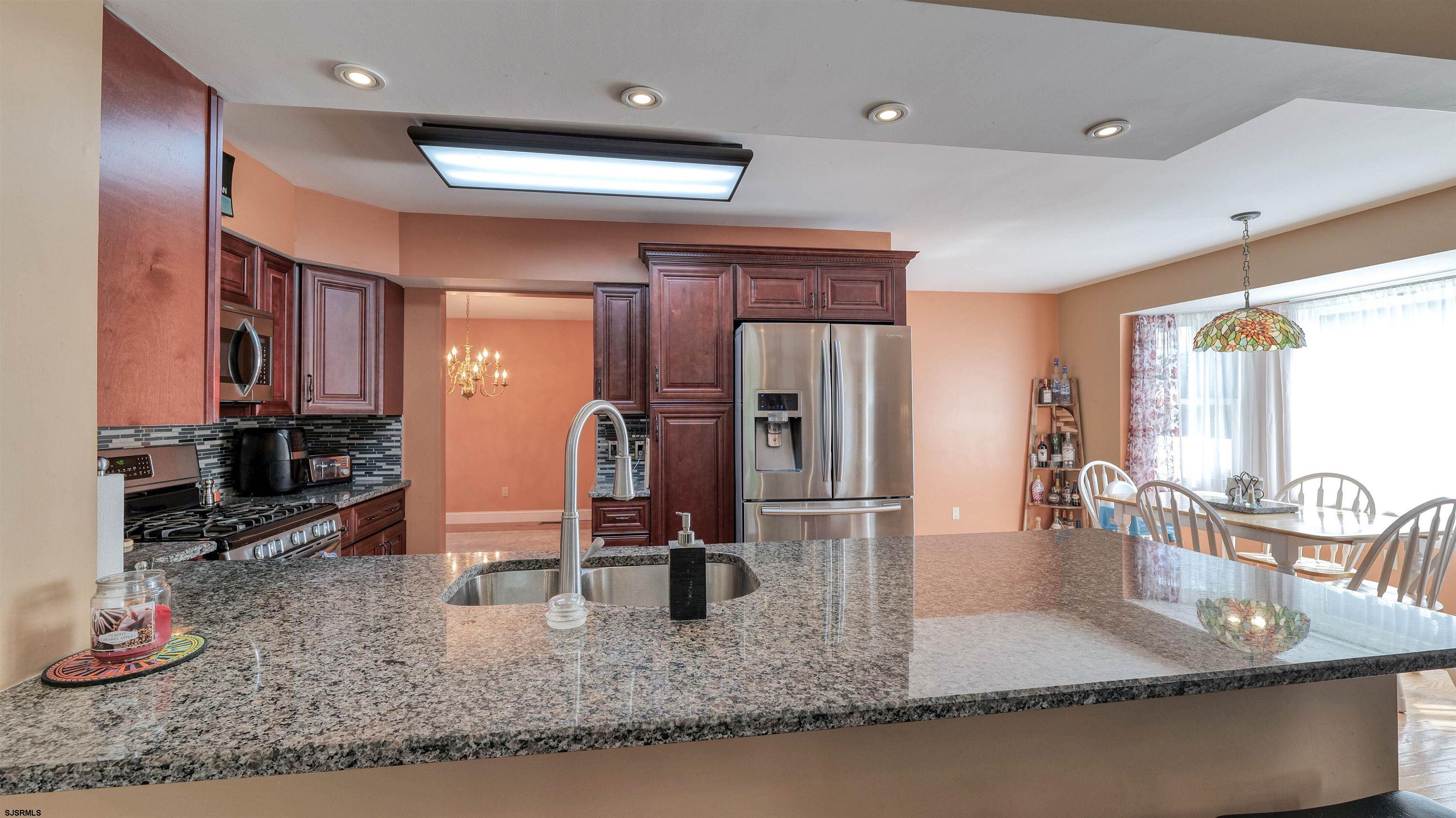 209 Reed Road Absecon, NJ 08201 - Photo 14 of 57 a kitchen with stainless steel appliances granite countertop sink stove and cabinets