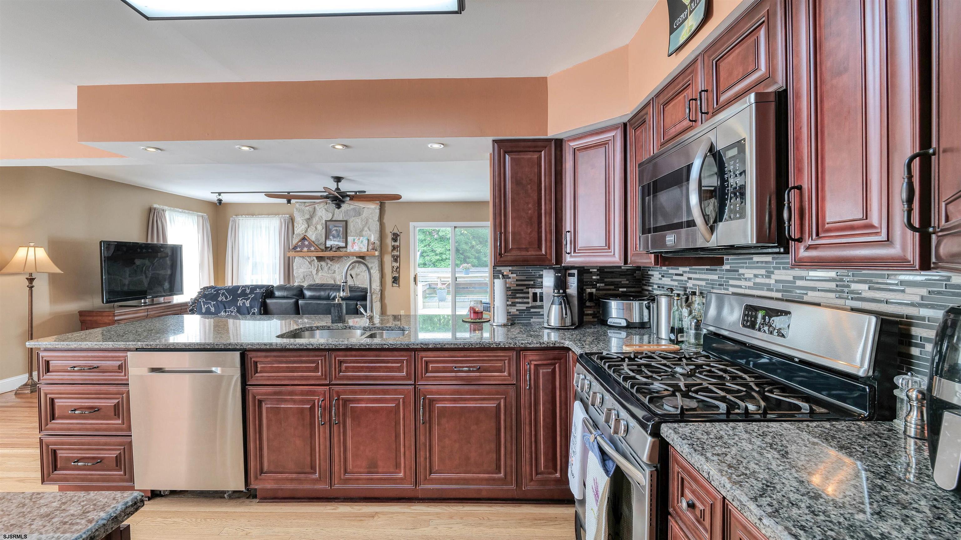 209 Reed Road Absecon, NJ 08201 - Photo 15 of 57 a kitchen with stainless steel appliances granite countertop a stove a sink and a microwave