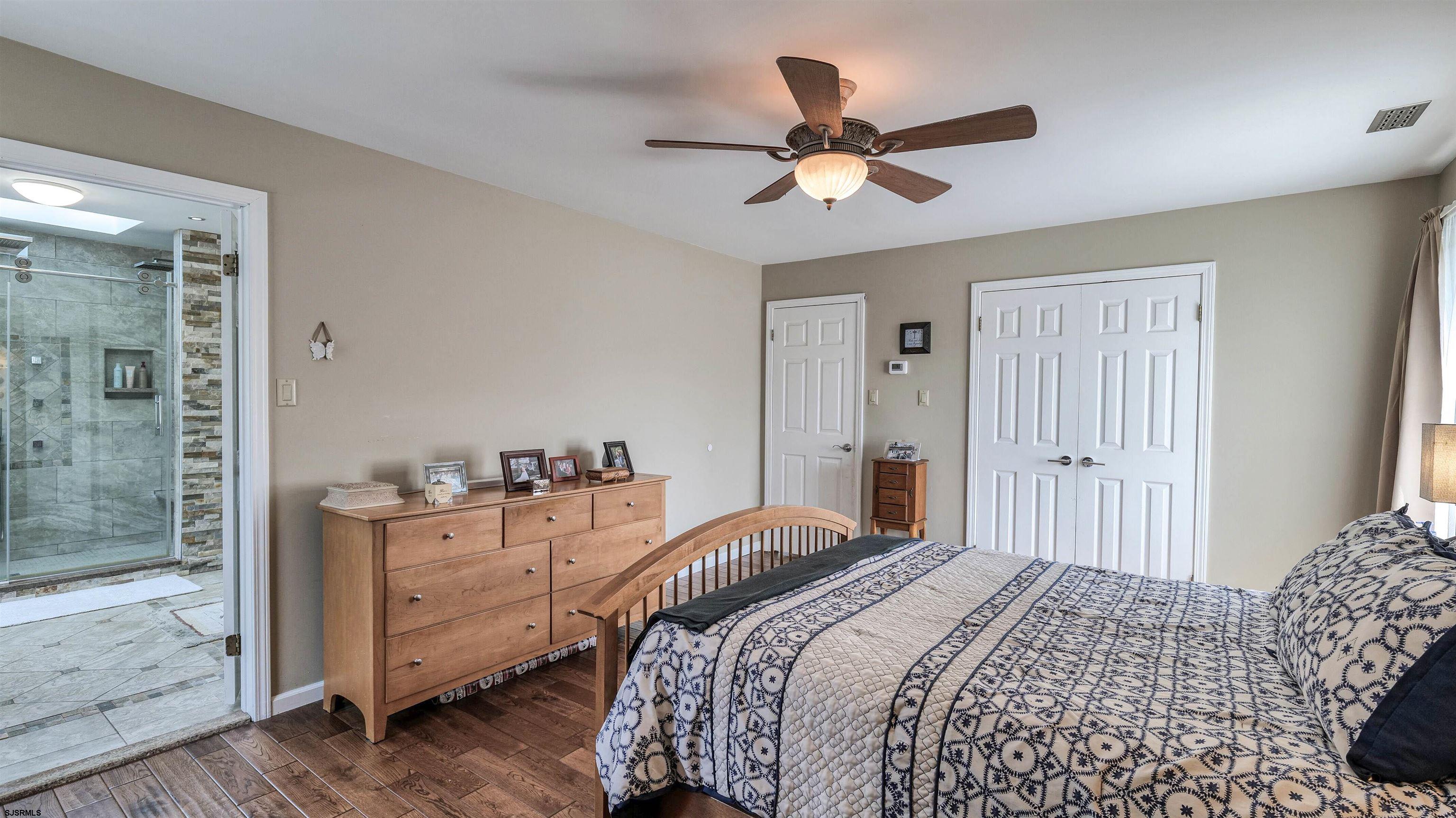 209 Reed Road Absecon, NJ 08201 - Photo 26 of 57 a bedroom with a bed and a chandelier