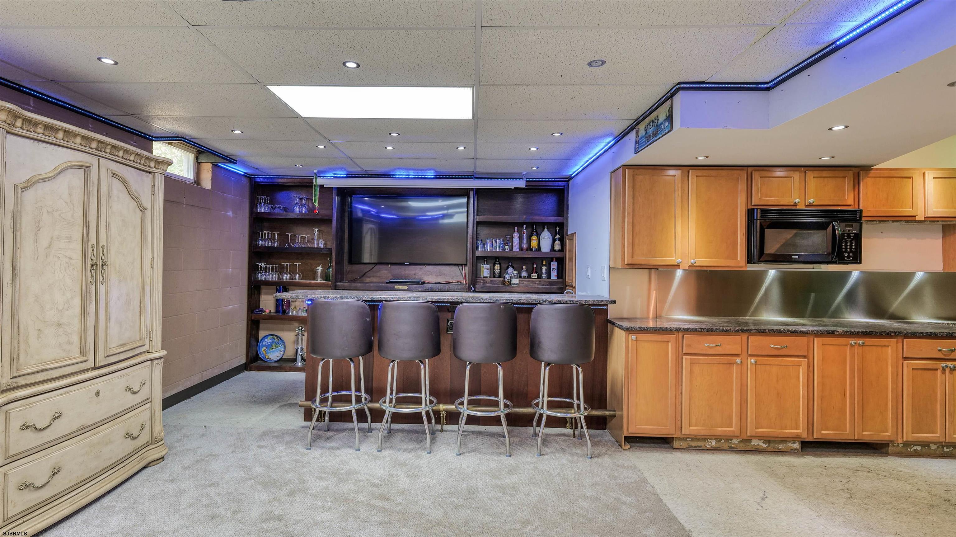 209 Reed Road Absecon, NJ 08201 - Photo 34 of 57 a kitchen with stainless steel appliances kitchen island granite countertop a table chairs sink and cabinets