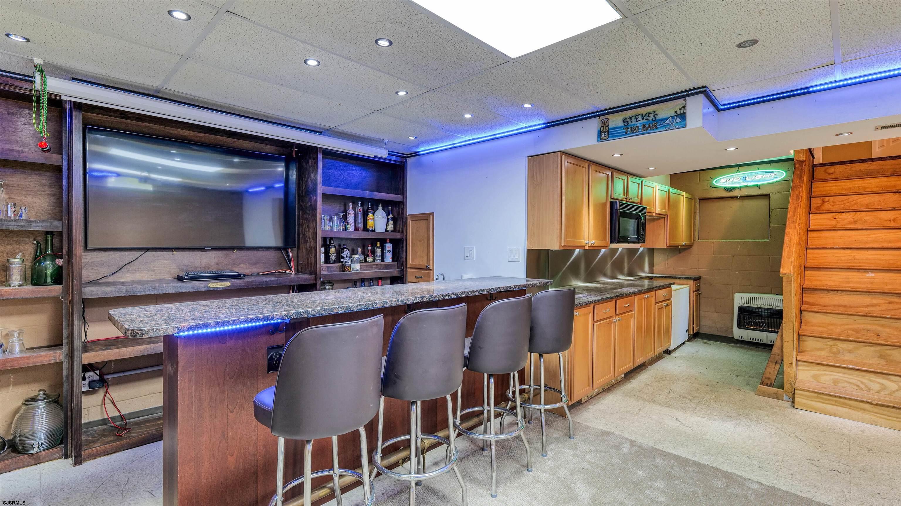 209 Reed Road Absecon, NJ 08201 - Photo 35 of 57 a kitchen with stainless steel appliances kitchen island granite countertop furniture and a flat screen tv