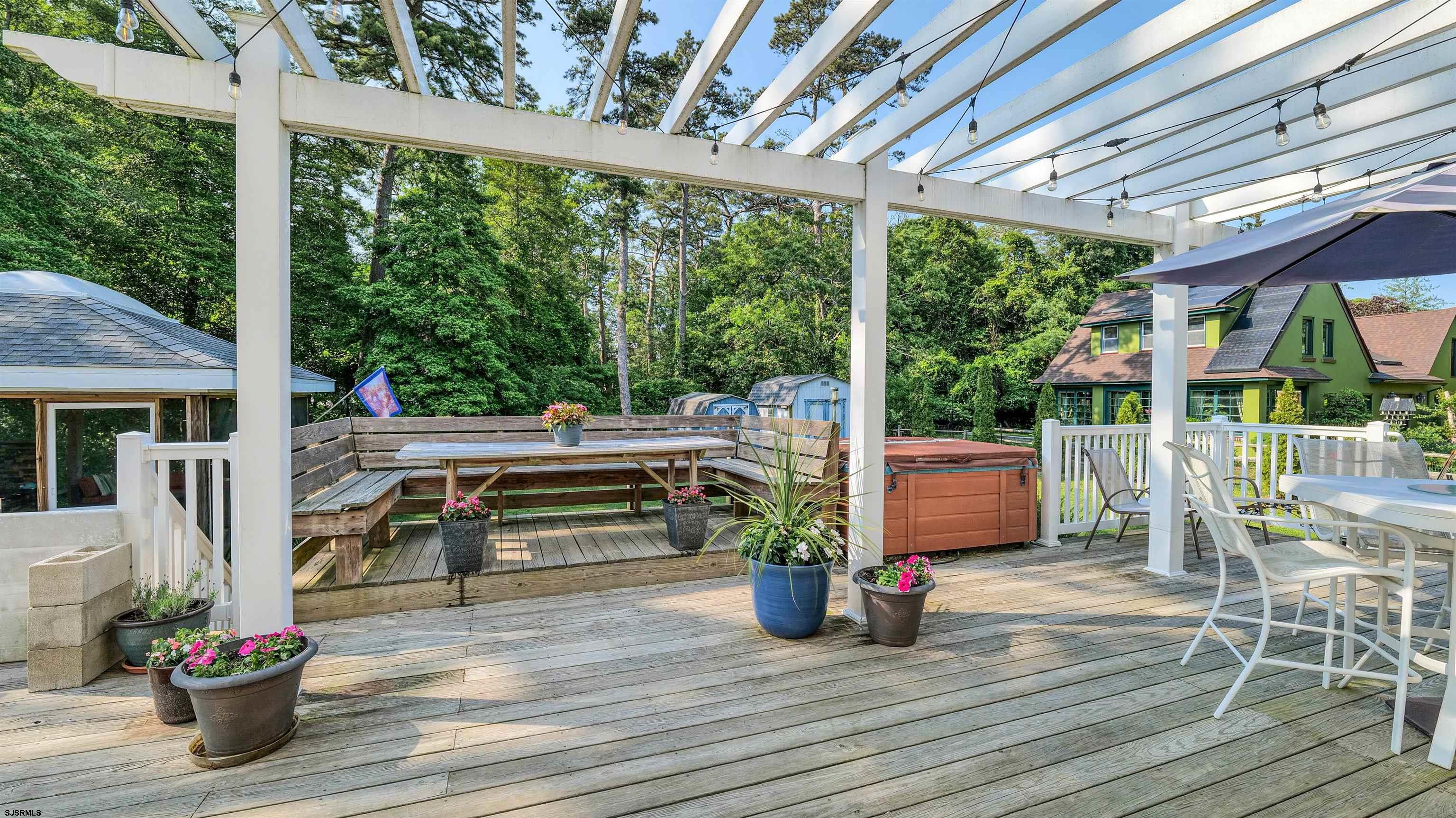 209 Reed Road Absecon, NJ 08201 - Photo 40 of 57 a view of a patio with table and chairs potted plants with wooden floor and fence