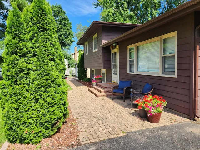 a view of a chairs and table in the back yard of the house