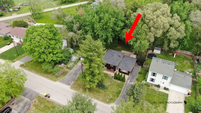 an aerial view of residential houses with outdoor space and trees