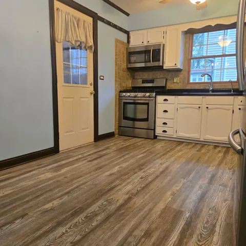 a view of room with wooden floor and lounge chair