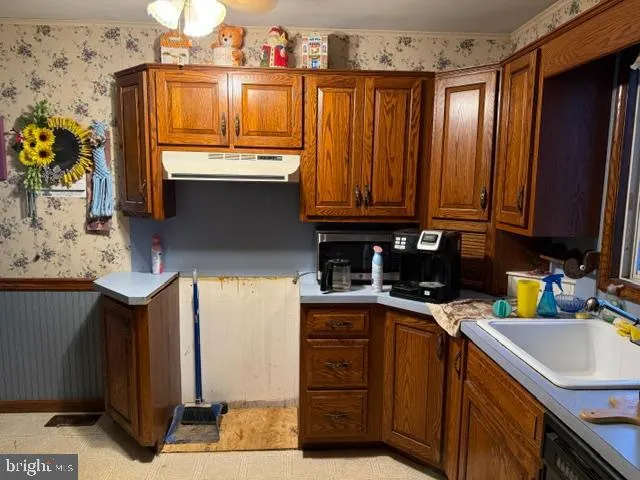 a kitchen with granite countertop a sink a stove and wooden cabinets