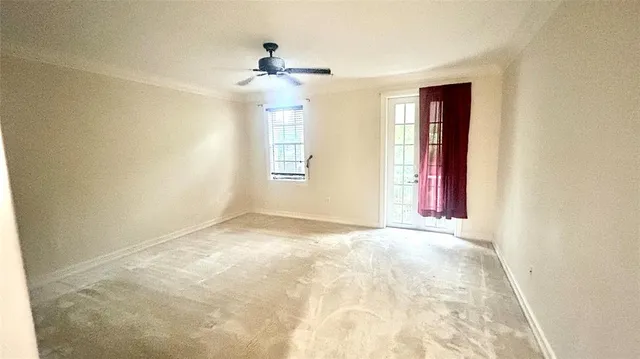 an empty room with windows and chandelier fan