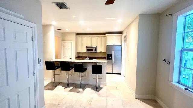 a kitchen with stainless steel appliances kitchen island granite countertop a refrigerator and a stove top oven