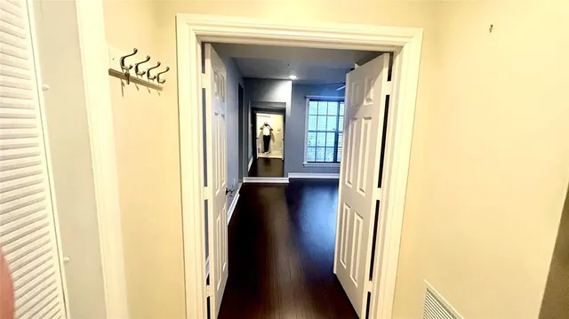 a view of a hallway with wooden floor