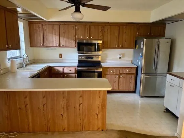 a kitchen with wooden cabinets and stainless steel appliances