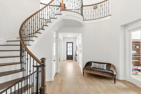 a view of entryway and hall with wooden floor
