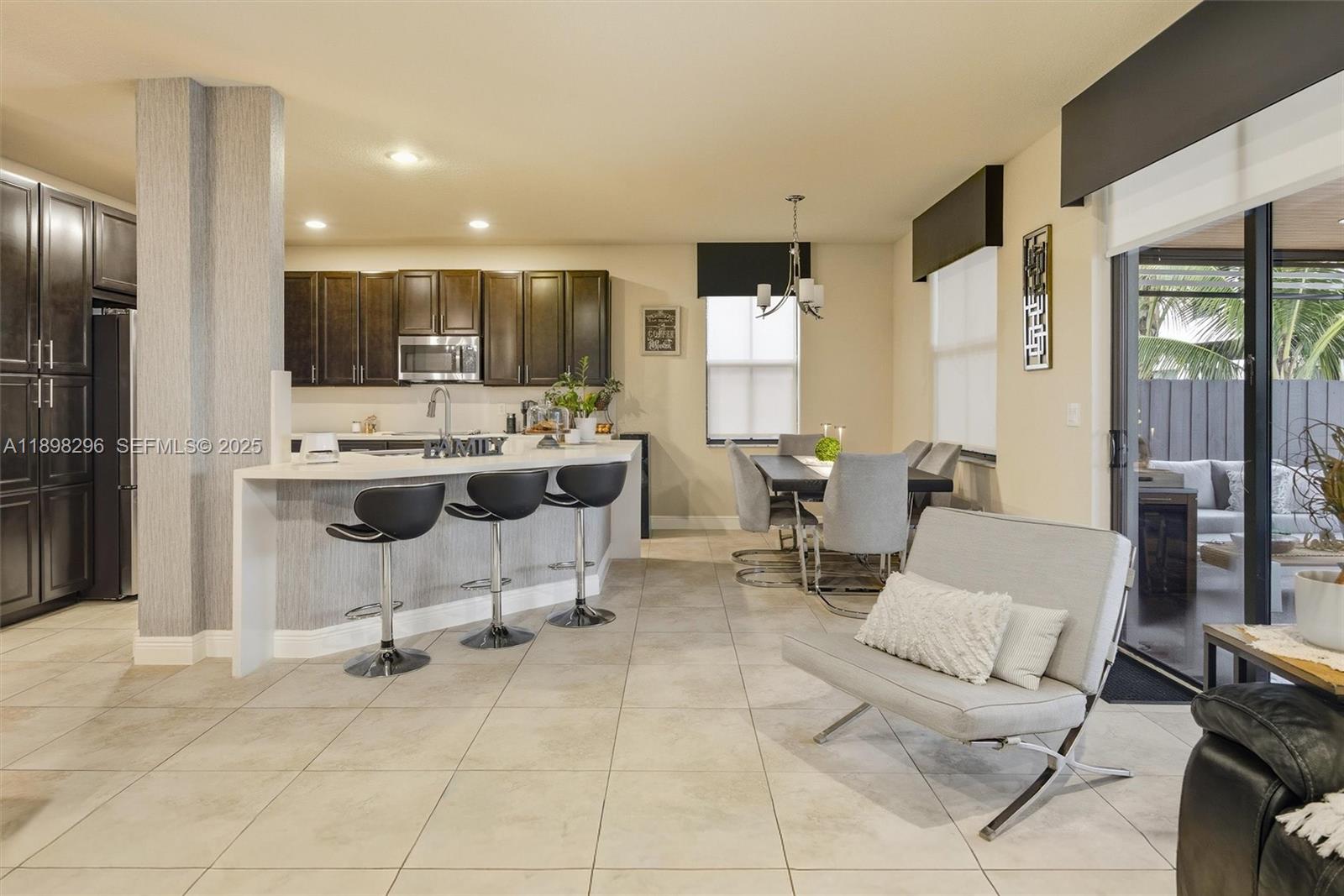 8870 Northwest 99th Path Doral, FL 33178 - Photo 13 of 44 a living room with furniture a large window and kitchen view