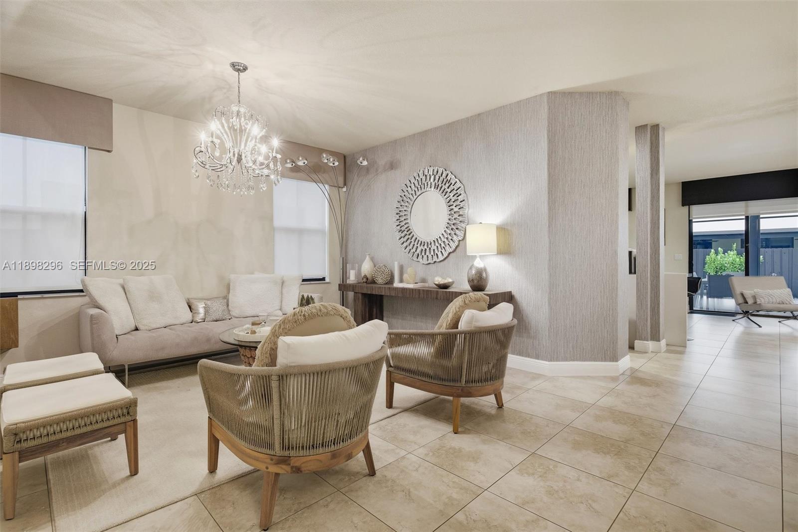 8870 Northwest 99th Path Doral, FL 33178 - Photo 4 of 44 a living room with couches a chandelier and a dining table with garden view