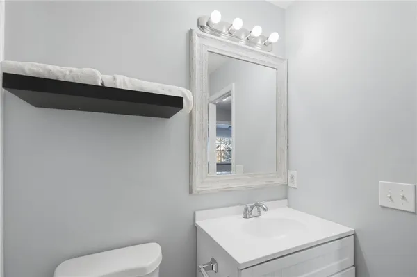 a bathroom with a toilet sink and mirror