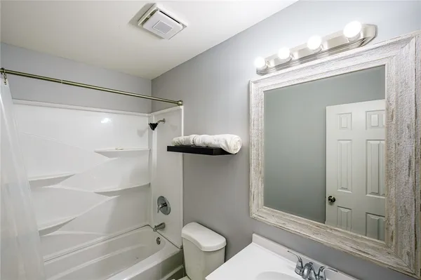 a bathroom with a granite countertop sink mirror vanity and toilet