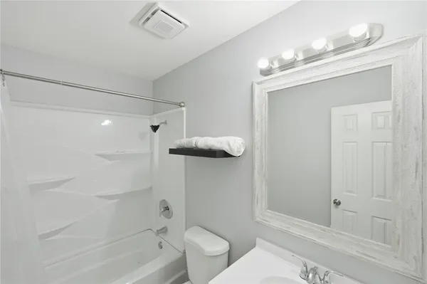 a bathroom with a shower a toilet and sink