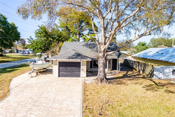 a view of a house with a yard covered with snow and trees