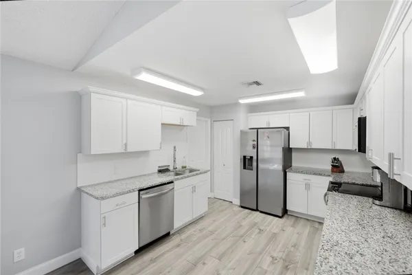 a kitchen with white cabinets and stainless steel appliances