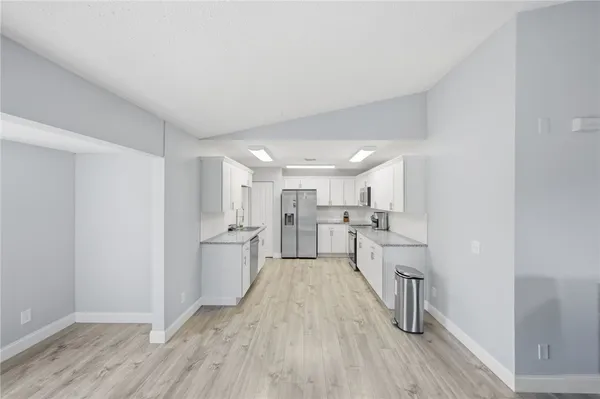 a view of a kitchen with a sink and wooden floor