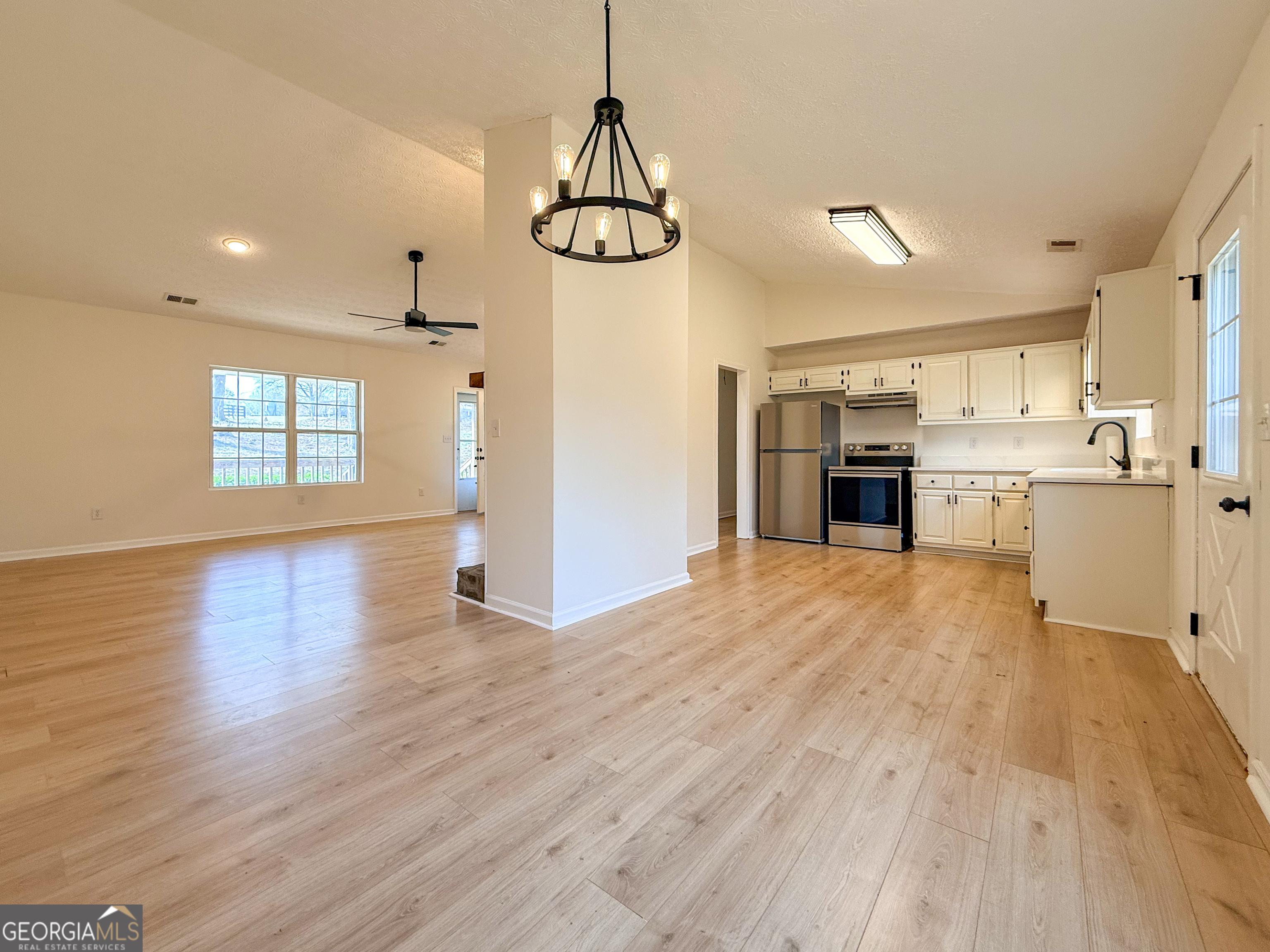 1492 Highway 198 Carnesville, GA 30521 - Photo 6 of 25 a view of empty room with wooden floor and kitchen view