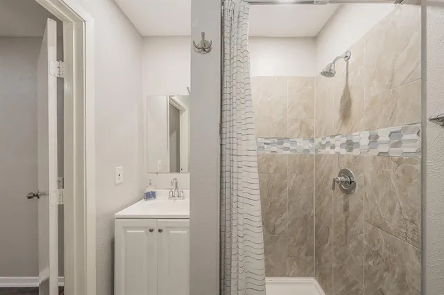 a bathroom with a sink a mirror and shower