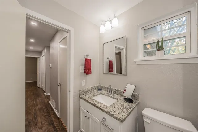 a bathroom with a granite countertop sink and a mirror
