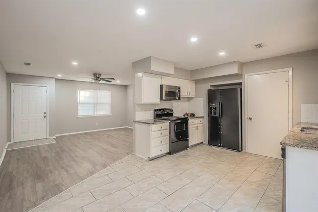 a kitchen with stainless steel appliances granite countertop a refrigerator sink and stove