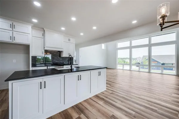 a kitchen with stainless steel appliances granite countertop a sink and dishwasher a stove top oven with wooden floor