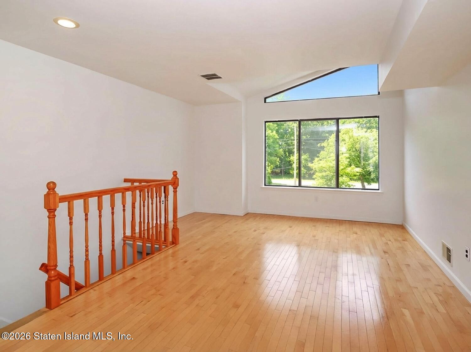 3438 A Amboy Road Staten Island, NY 10306 - Photo 4 of 21 wooden floor in an empty room with a window