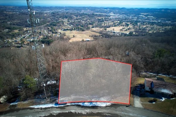 an aerial view of residential houses with outdoor space and lake view
