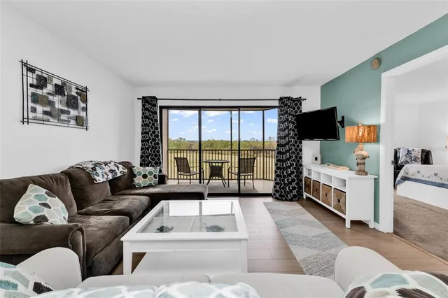 a view of a dining room and livingroom with furniture wooden floor a rug and a chandelier