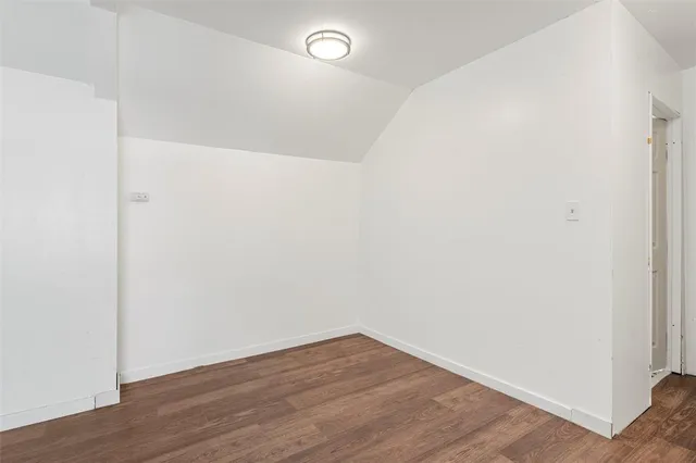 a view of a room with wooden floor and a window