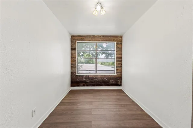an empty room with wooden floor and window