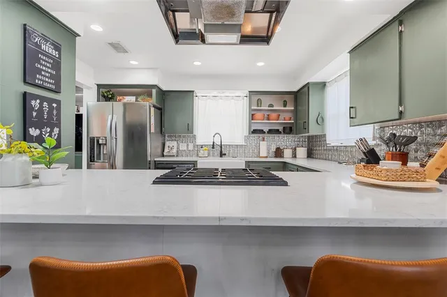 a kitchen with stainless steel appliances granite countertop a sink a stove and a refrigerator