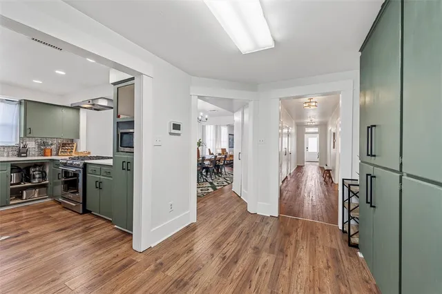 a kitchen with a refrigerator and wooden floor