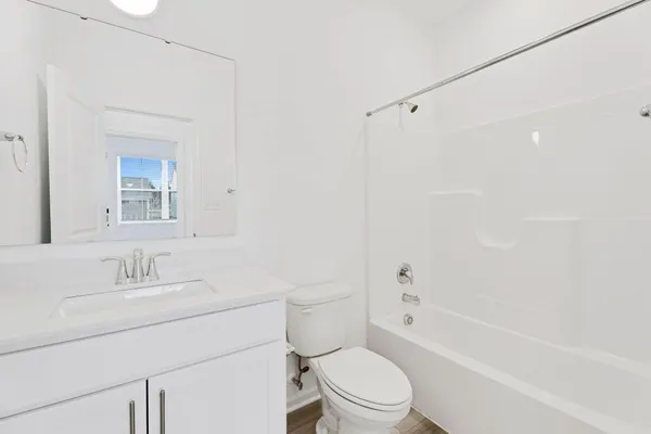 a bathroom with a sink toilet vanity and shower
