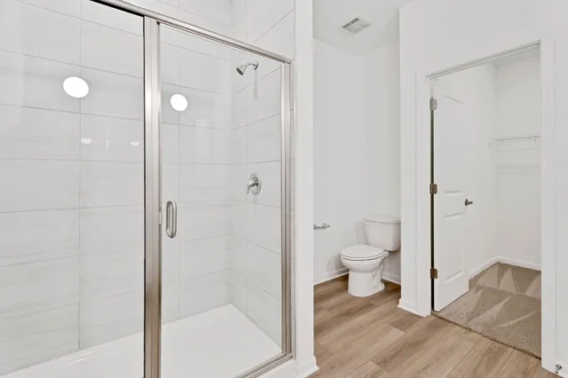a bathroom with a granite countertop toilet a sink and shower